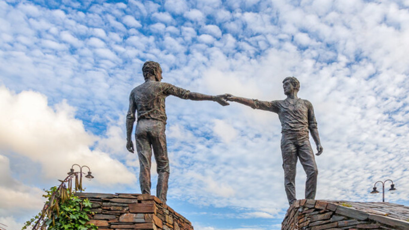 The sculpture "Hands Across the Divide" in Derry. A compelling image that encapsulates the journey of mediation in Northern Ireland; from its roots in intense conflict to its application in everyday settings. This bronze and silver statue, created by local artist Maurice Harron and erected in 1992, symbolises reconciliation between both sides of the political divide during The Troubles. It poignantly represents the bridging of communities and the enduring power of relationship-building in mediation. 