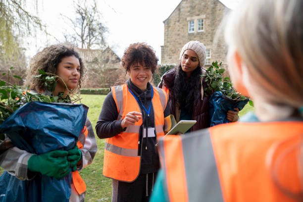 Community in Action. Volunteers in orange vests collaborate outdoors, symbolising the tangible impact of social initiatives. This image highlights the collective effort and direct engagement that drive positive change within the community