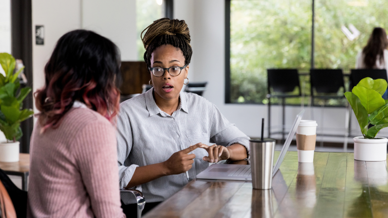 Line manager having a supportive one-on-one conversation with a team member to address early signs of workplace conflict and promote open communication