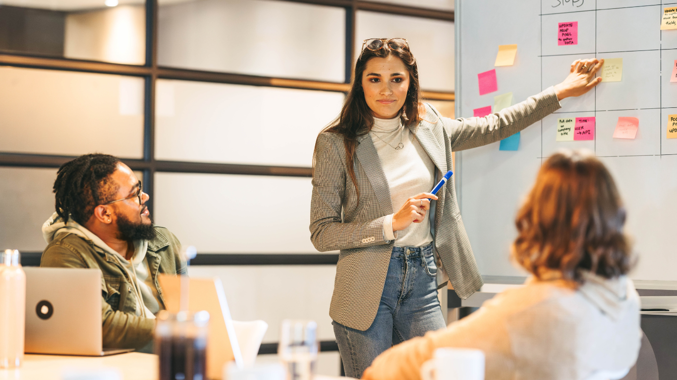 A team leader engaging in an empathetic conversation with colleagues in a modern office, symbolising conflict awareness and the development of mediation skills in workplace leadership.